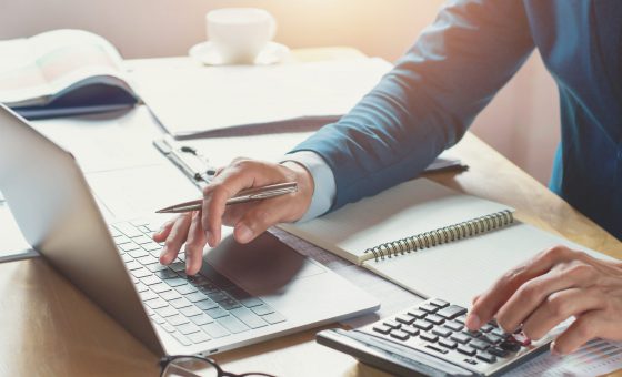 Empresario trabajando en la oficina usando una calculadora y una computadora portátil. concepto de finanzas y contabilidad